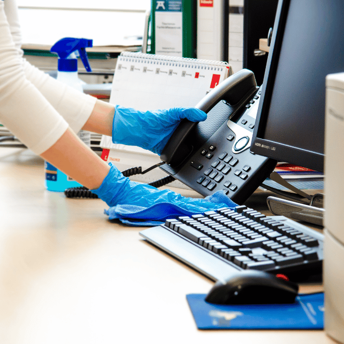 Reinigungsdame bei der Reinigung eines Schreibtisches in einem Büro in Salzburg